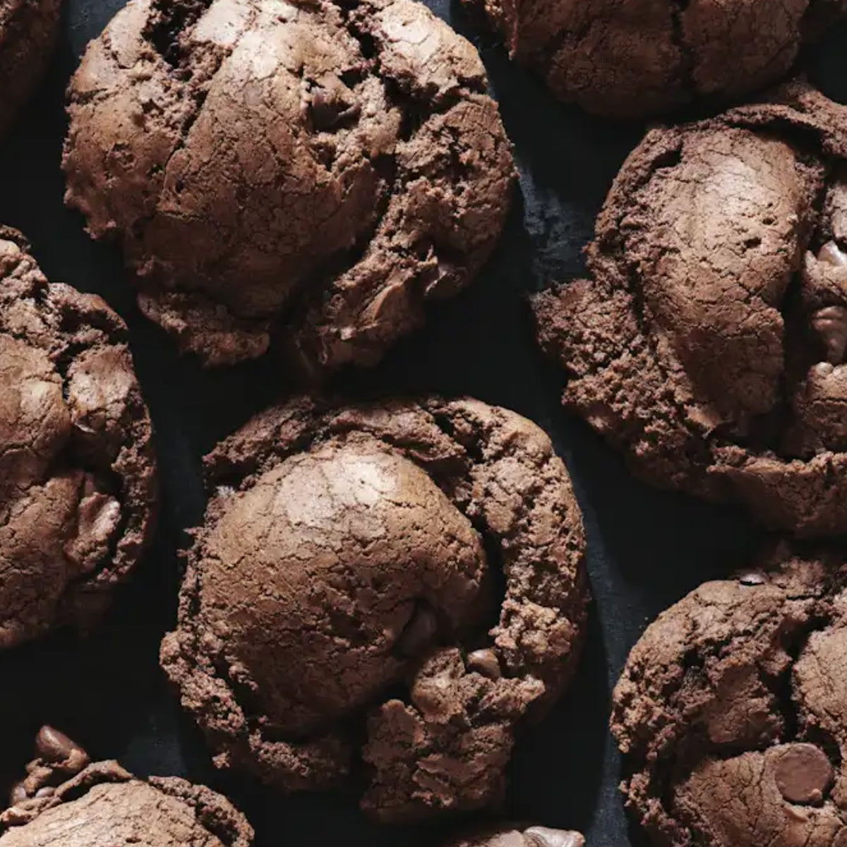 Close-up of chocolate brownie cookies on a dark surface.