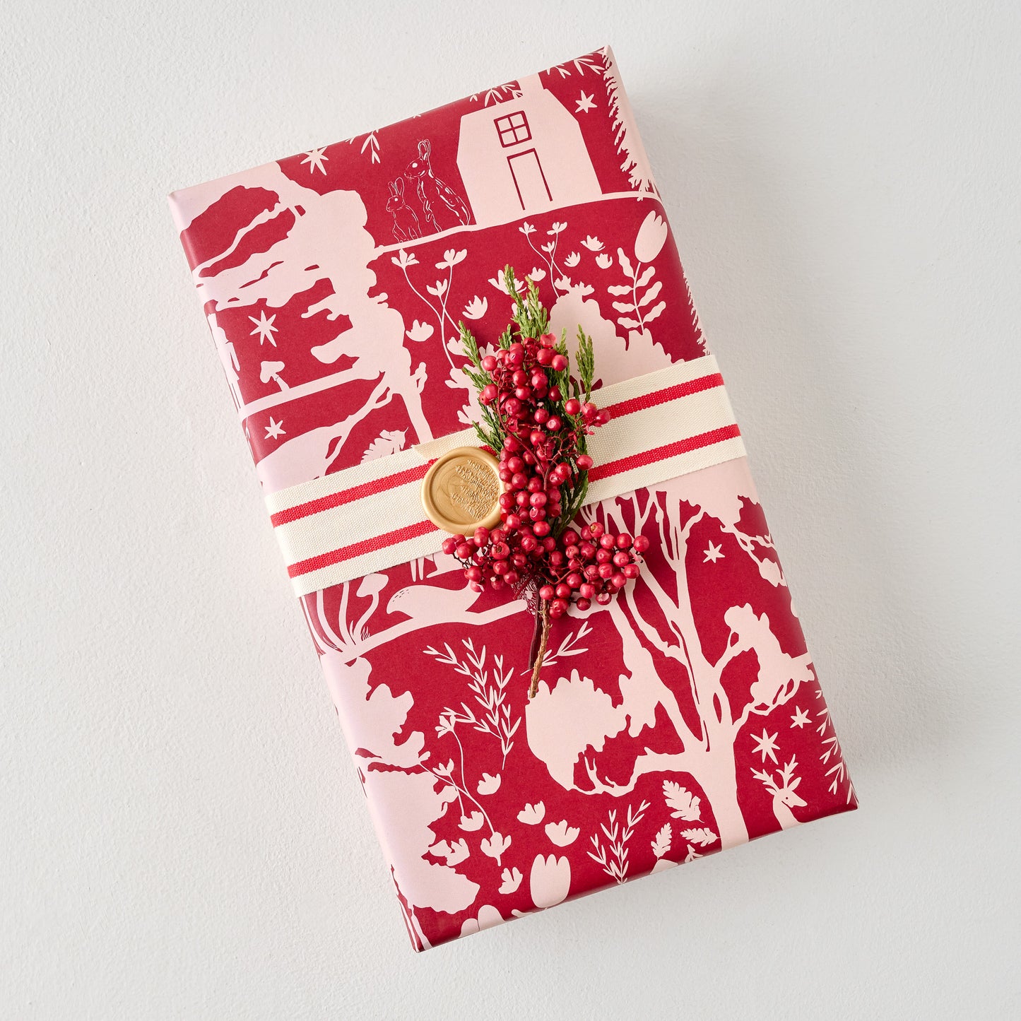 Magnolia Burgundy Woodland Wrapping Paper Sheets shown on gift