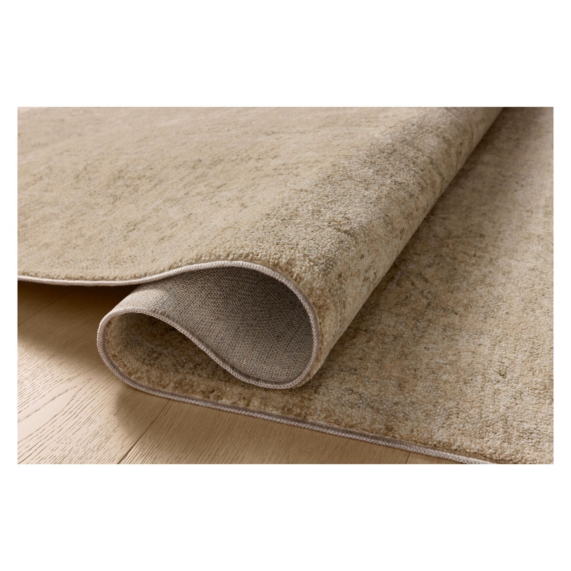Junie Oatmeal Smoke Rug shown rolled over itself