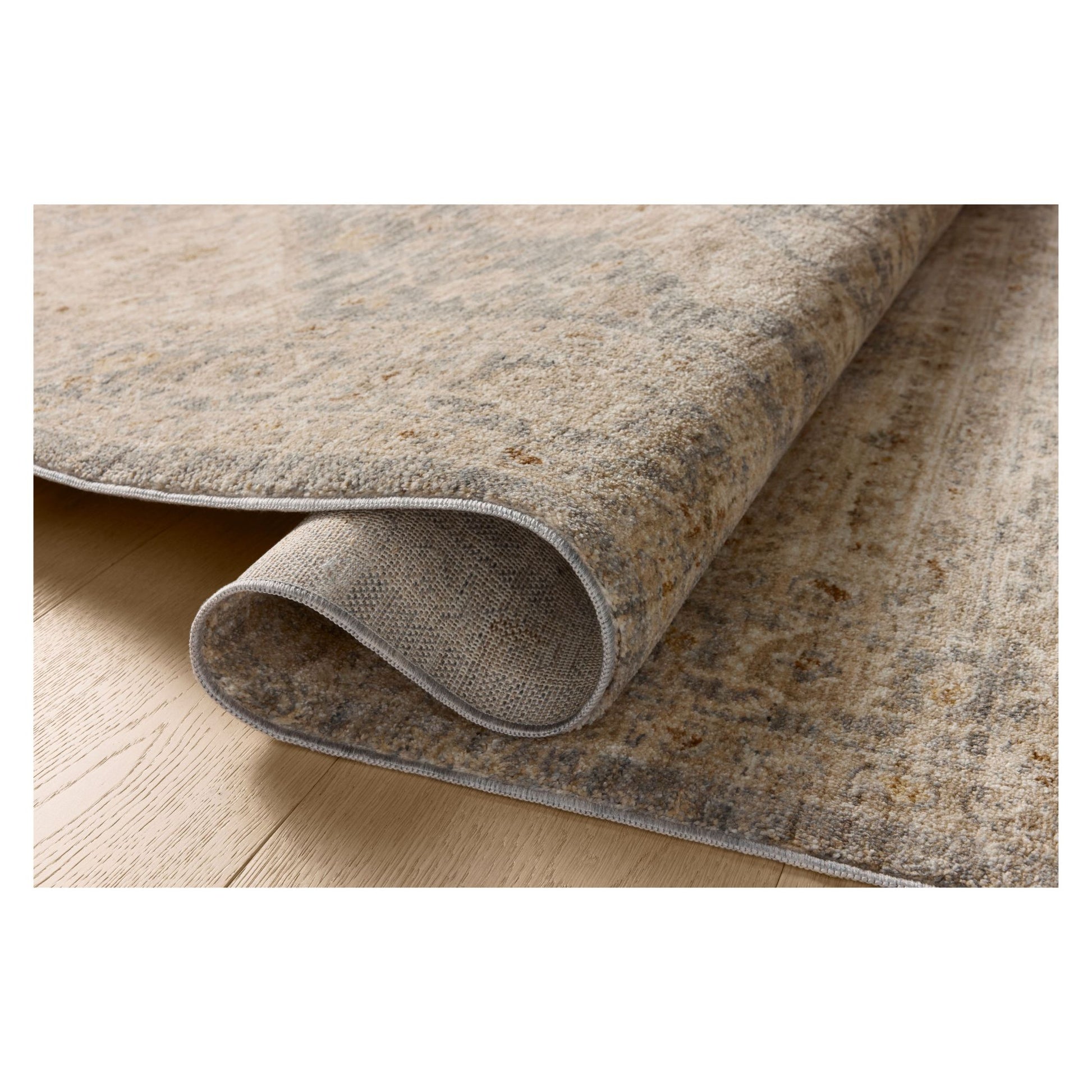 Junie Denim Natural Rug shown rolled over itself