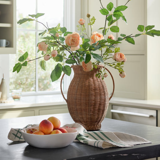 Real Touch Ranunculus Stem shown in rattan vase on kitchen counter