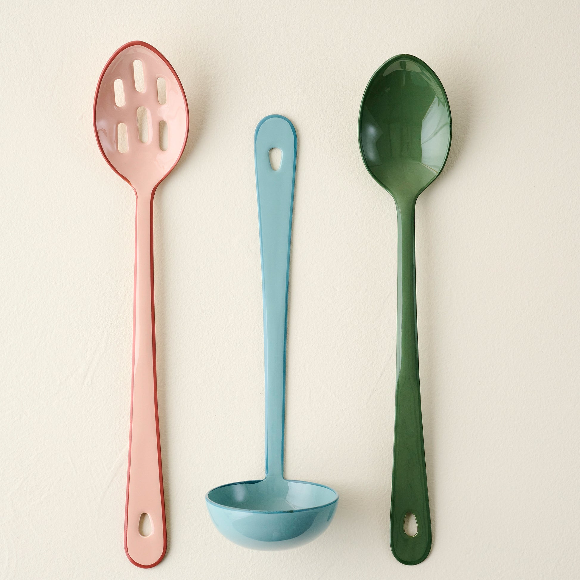 Vineyard Green Enamel Spoon shown with other colorful kitchen tools