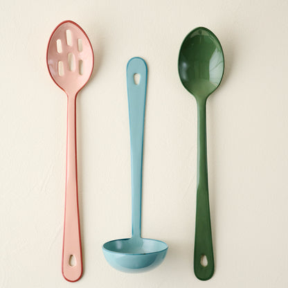 Vineyard Green Enamel Spoon shown with other colorful kitchen tools