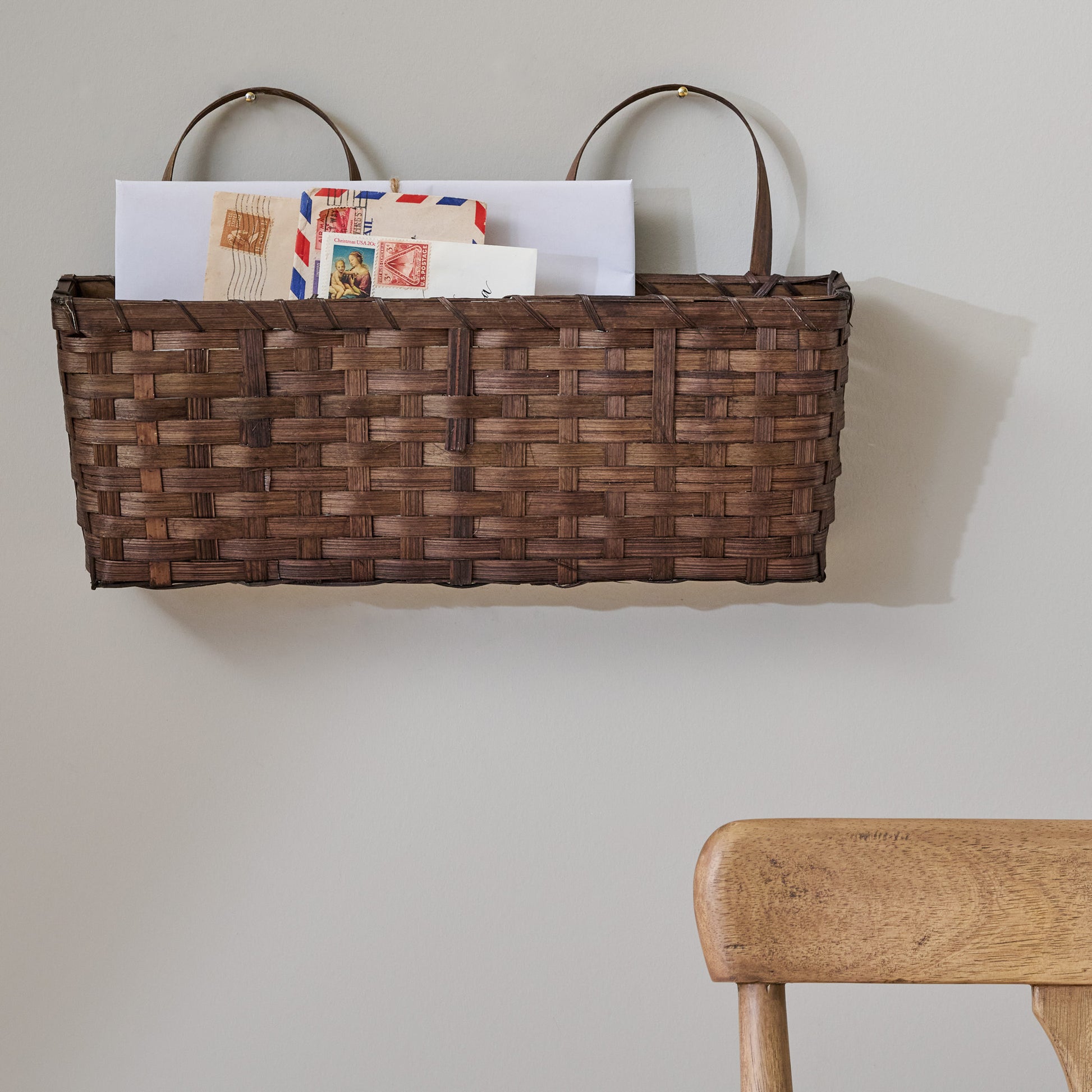 Small Damian Woven Wall Basket shown holding letters