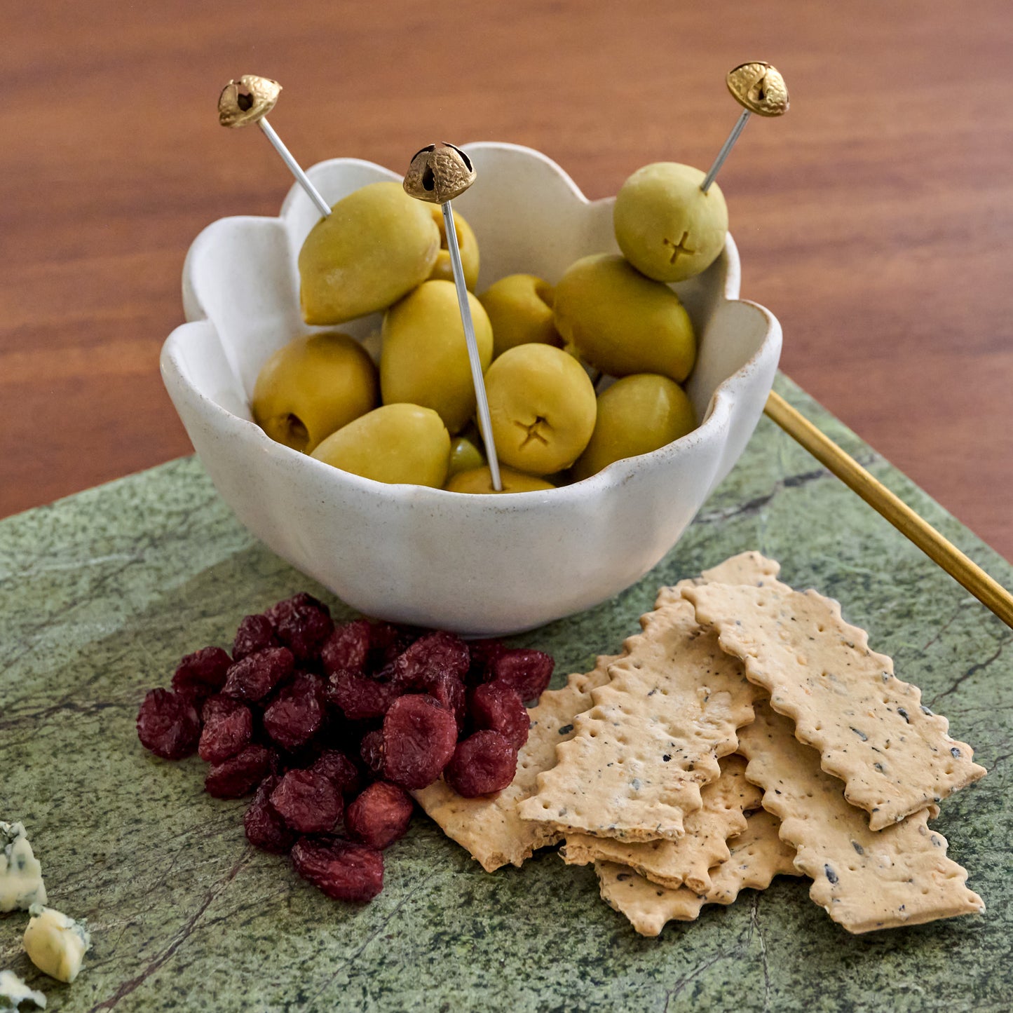 Brass Jingle Bell Cocktail Picks shown in bowl of oilves
