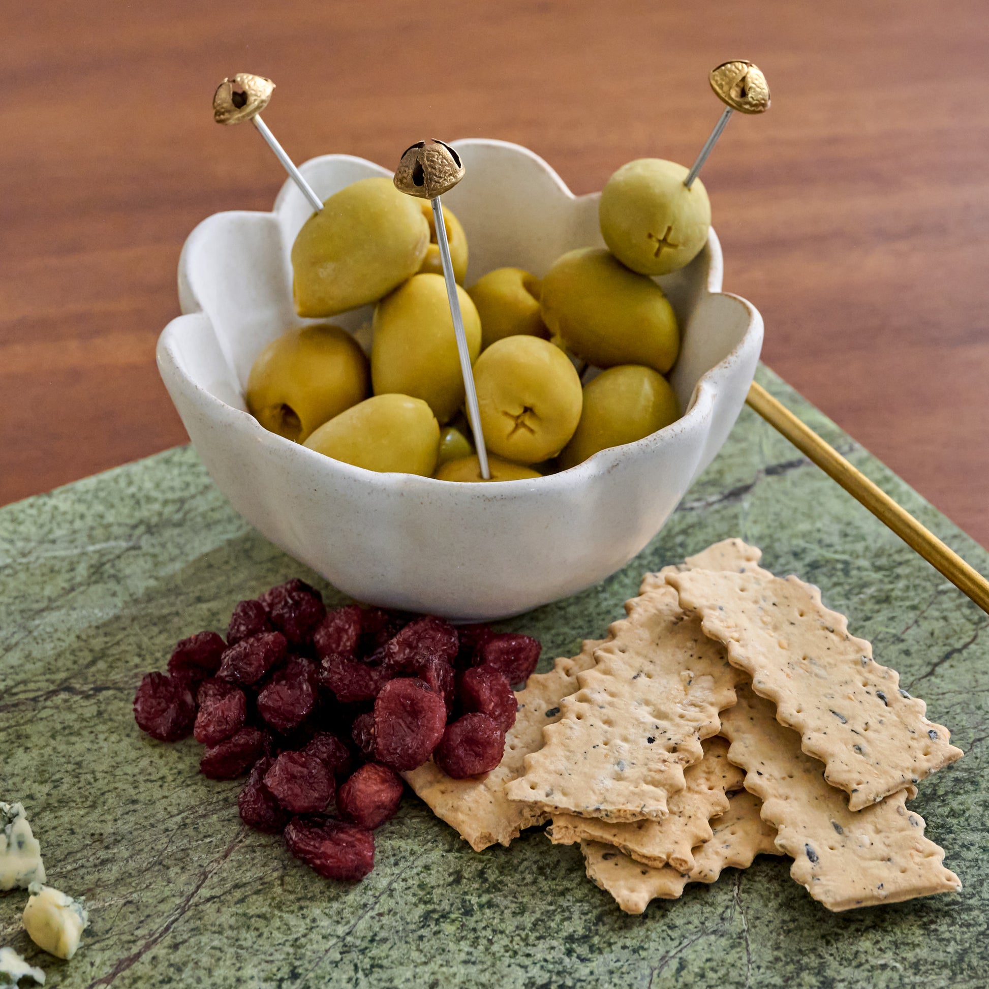 Brass Jingle Bell Cocktail Picks shown in bowl of oilves