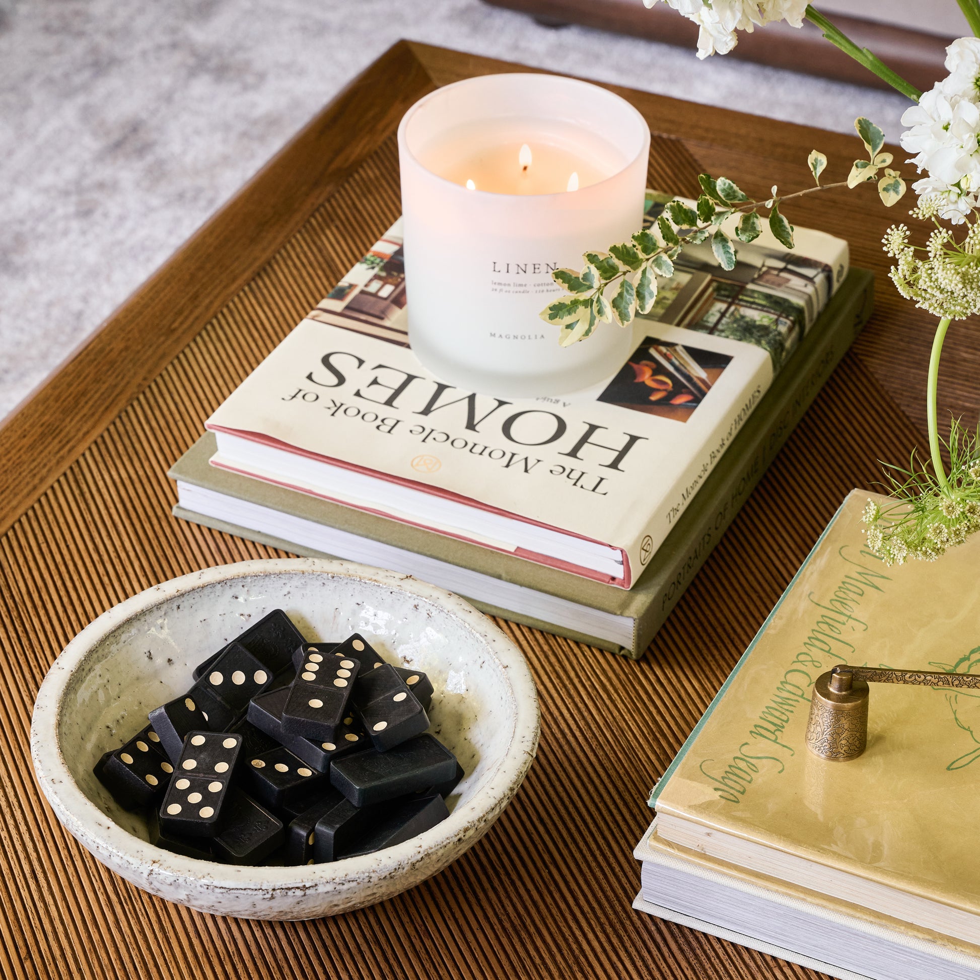 rustic cream accent bowl containing black dominoes  sits on a coffee table