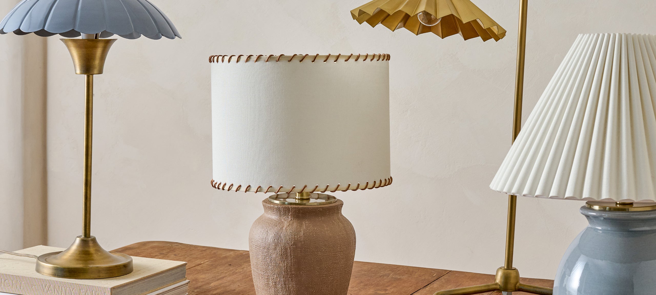 Three decorative lamps with different designs on a wooden surface.