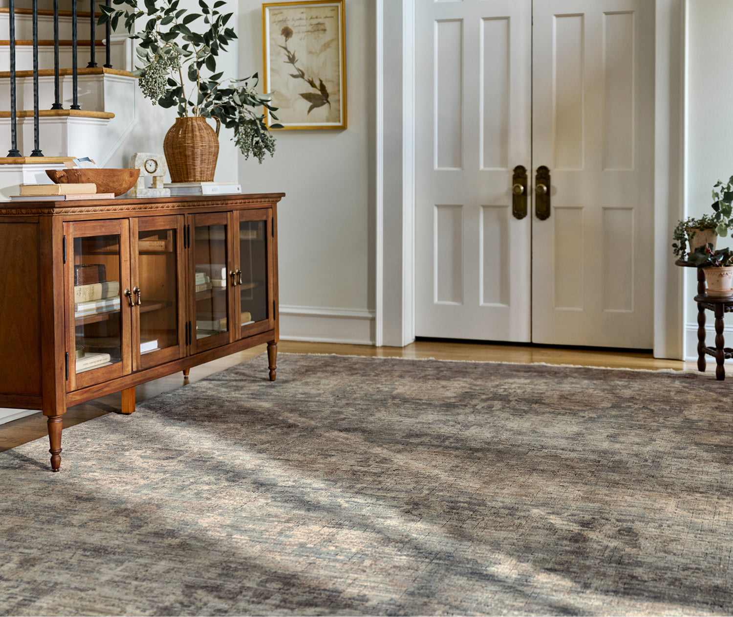 Living room with wooden cabinet, rug, and white doors.