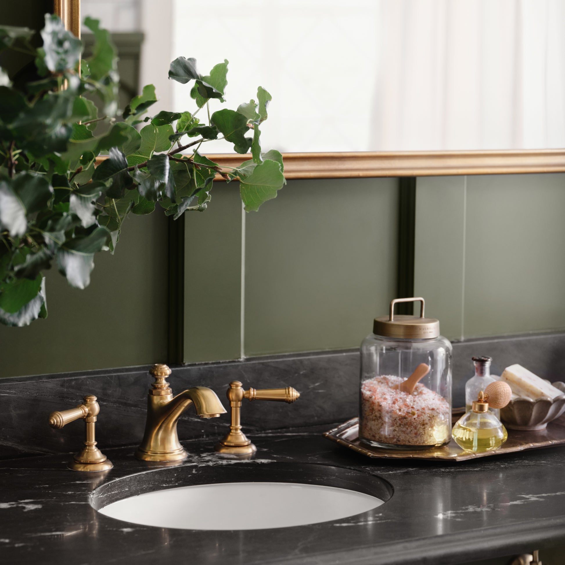 Antique Brass and Glass Canister on a tray on a bathroom counter with bath salts inside