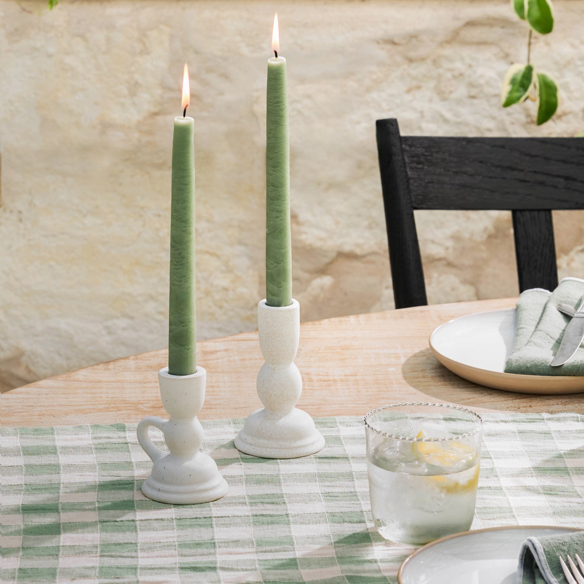 Colonial Green Taper in a taper holder on a table