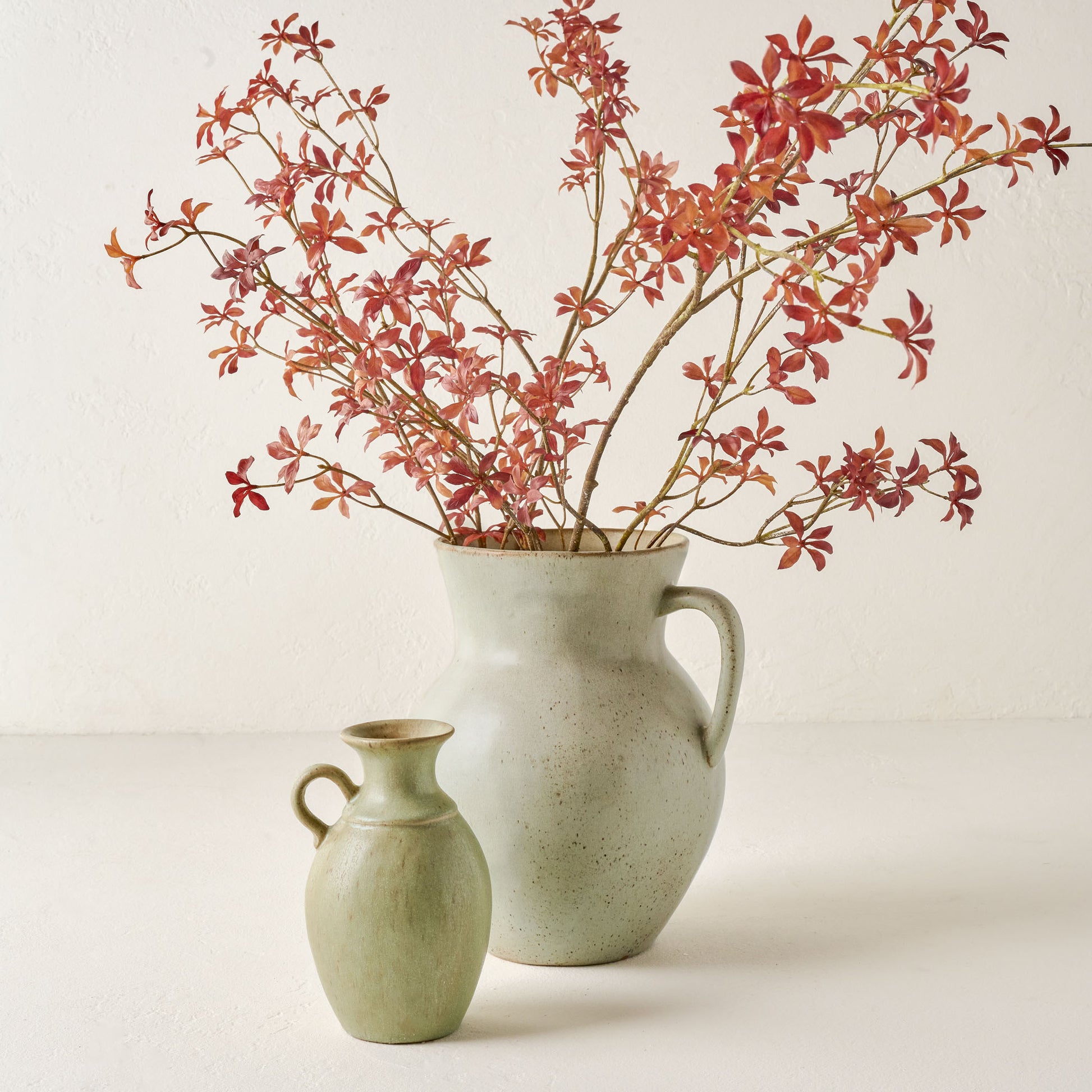 Maple Leaf Spray shown in light vase with smaller empty vase nearby