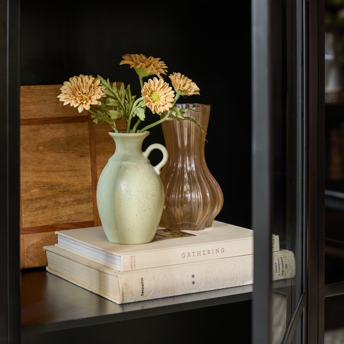 Small Rustic Green Vase shown holding florals in cabinet