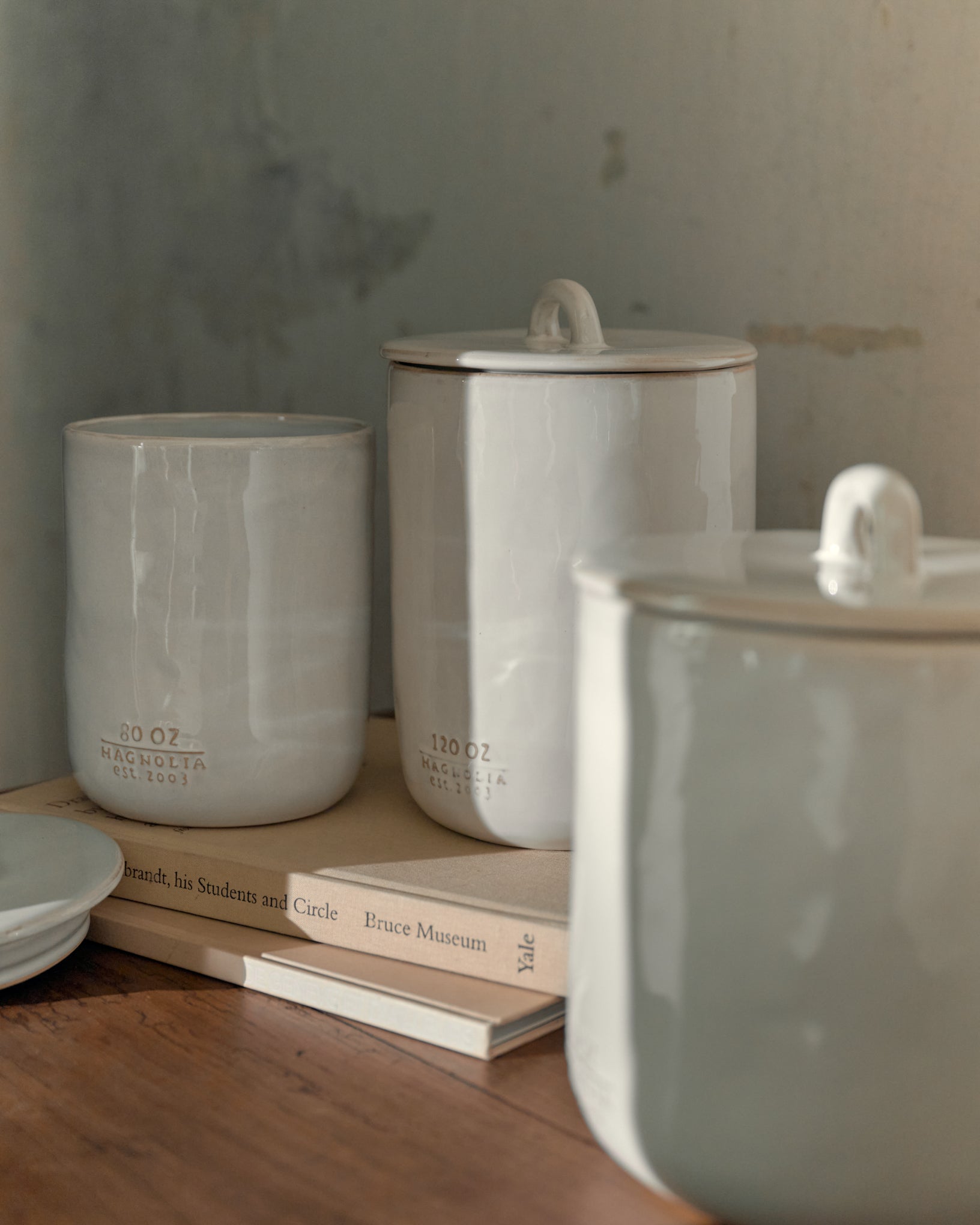 Mia Ceramic Canister on top of books