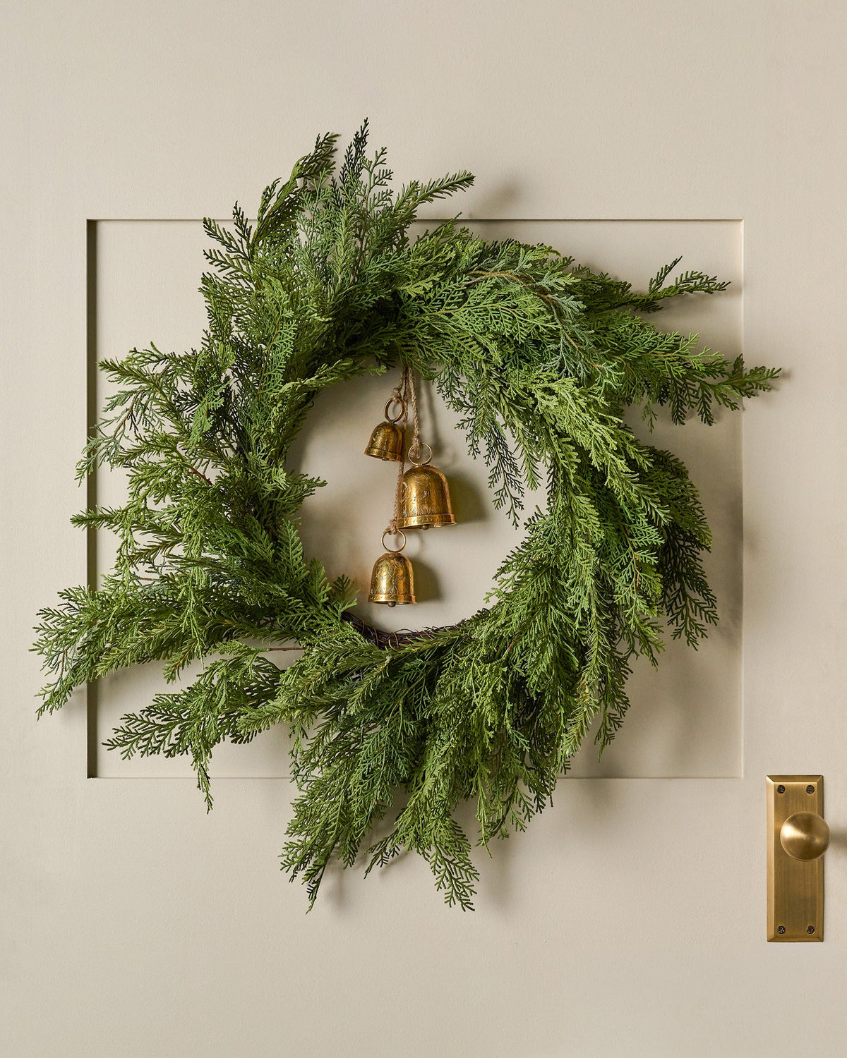 Real Touch Cedar Mix Wreath shown hung on door with bells