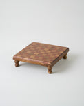 Wooden riser with checkered top on a white background