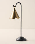 large sized brass scallop bell hanging from black metal stand