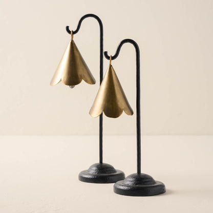 large and small sized brass scallop bells hanging from black metal stand