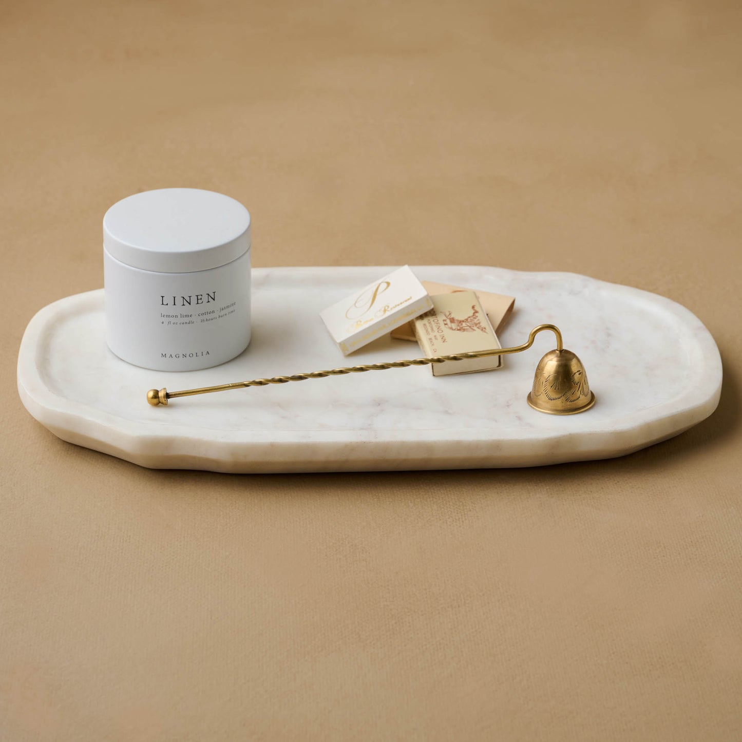 Vintage Inspired Candle Snuffer on a marble tray next to linen candle tin