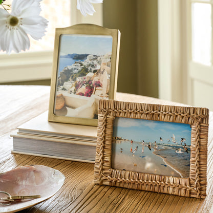 Beveled Antique Brass Photo Frame next to a rattan photo frame