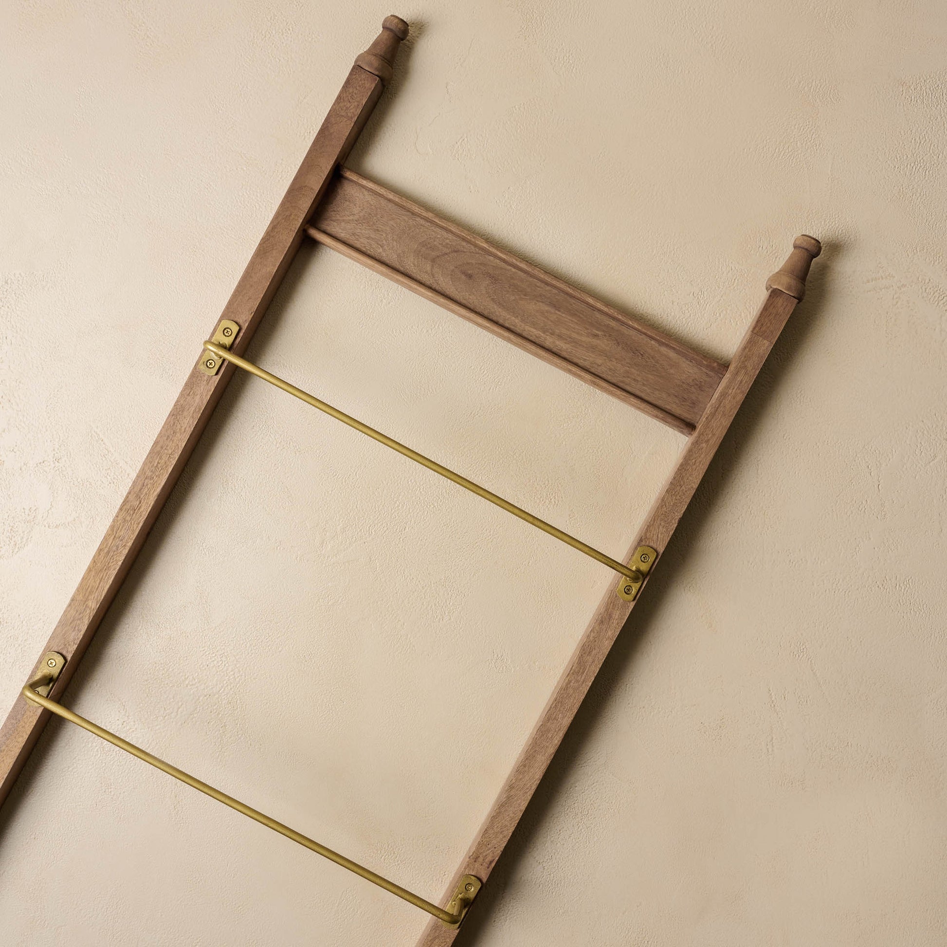 Brass and Wood Library Ladder against a beige surface