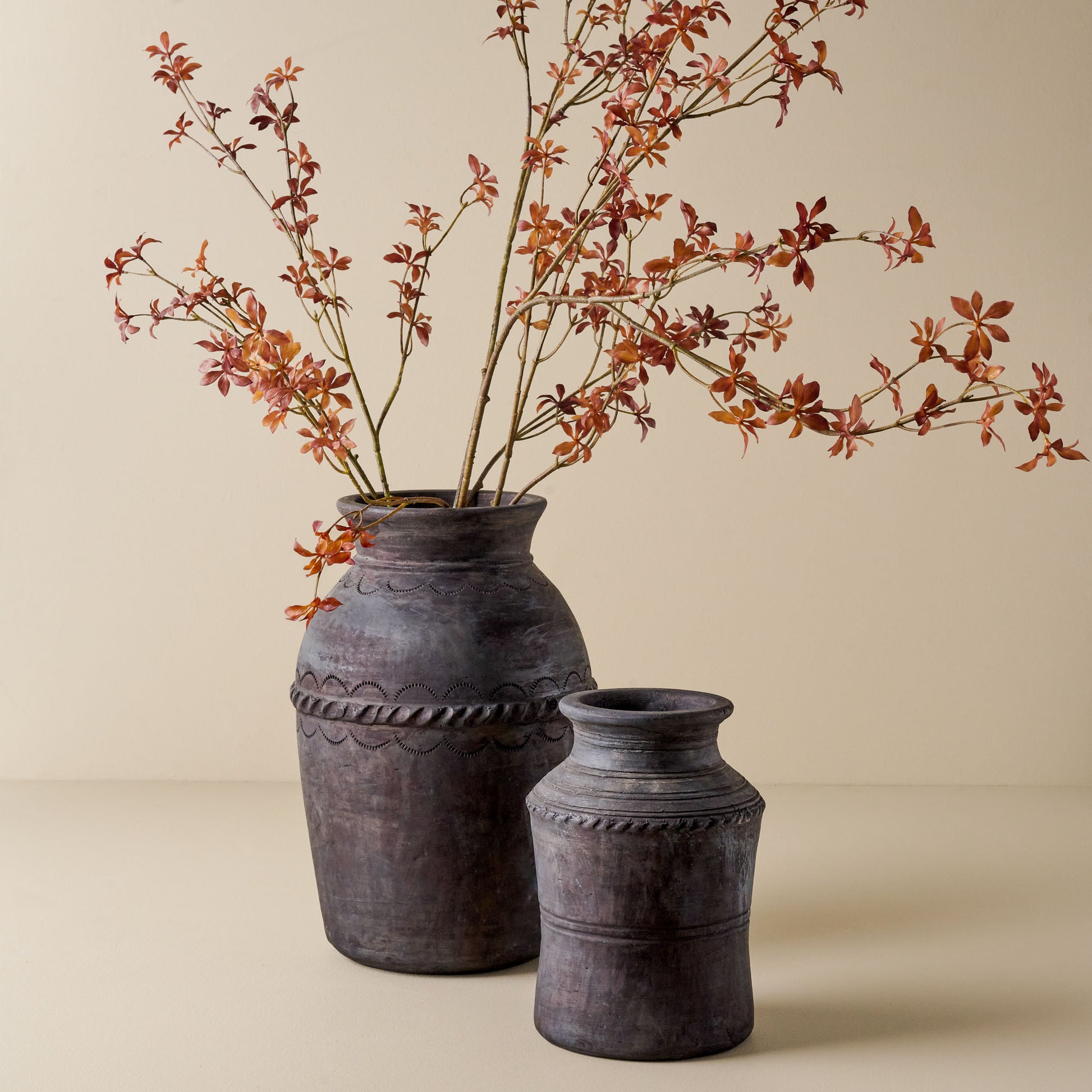 Maple Leaf Spray shown in black vase with smaller empty vase nearby