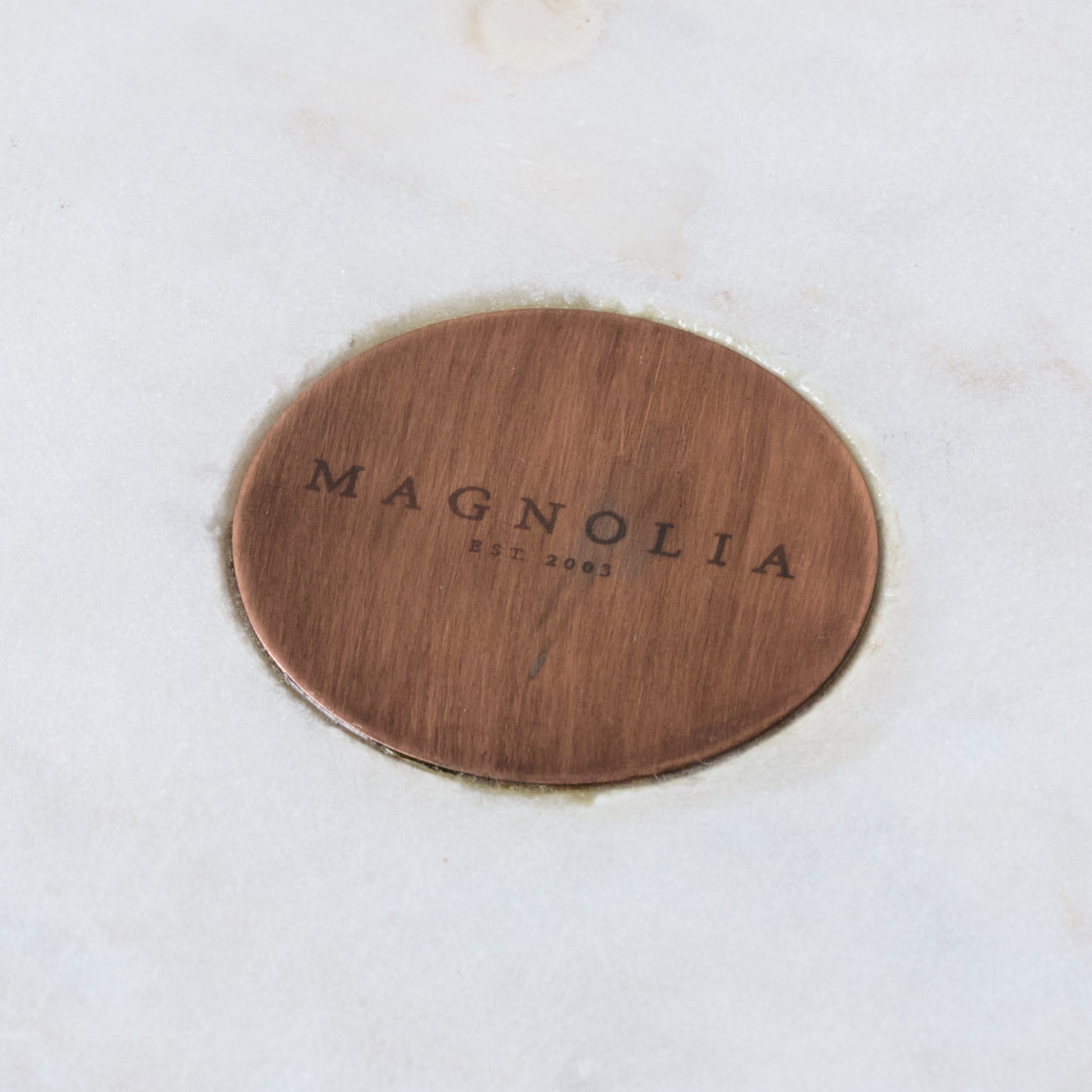 Marble and Copper Cake Stand close up of magnolia logo on center of marble