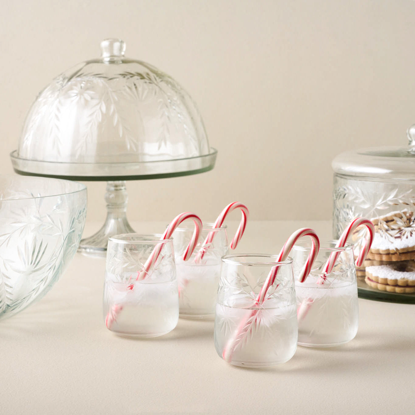 Vivian Cut Glass Stemless Glass with candy canes inside next to other vivian cut items