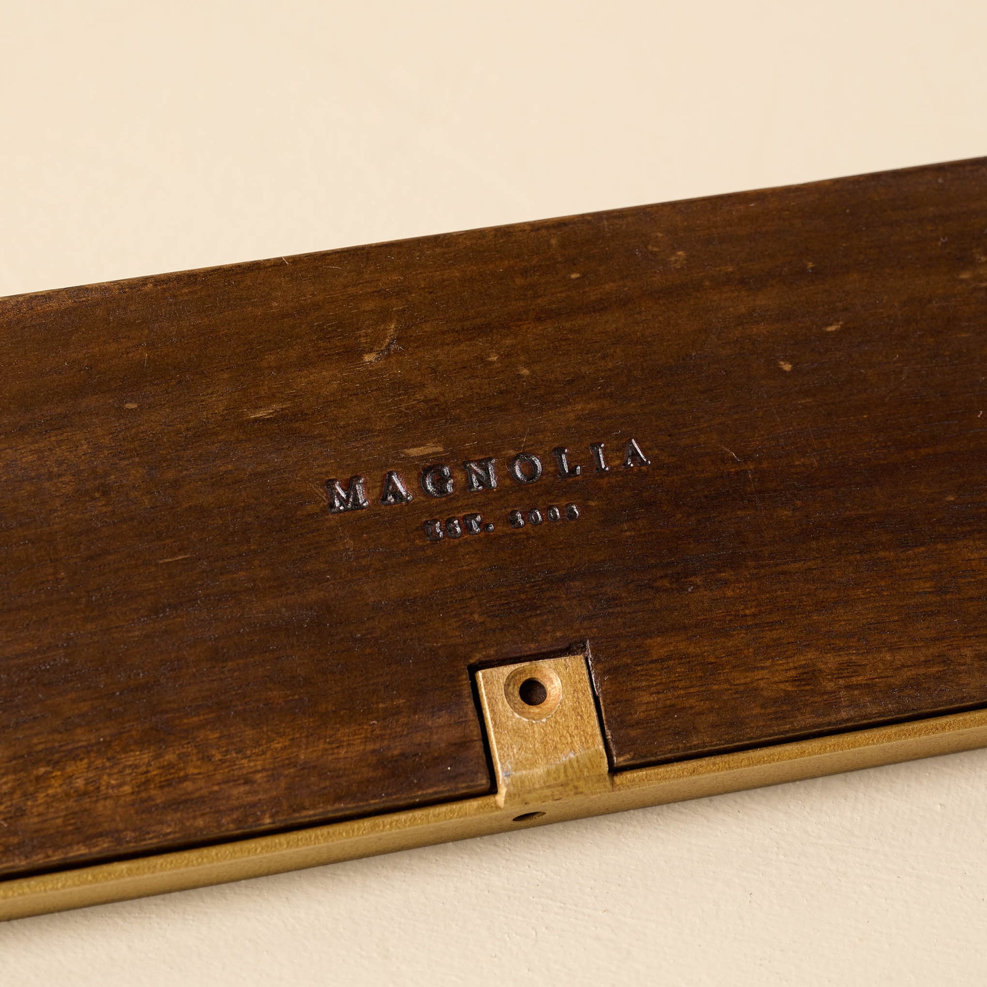Elliott Wood and Brass Picture Ledge close up of magnolia logo etched into wood
