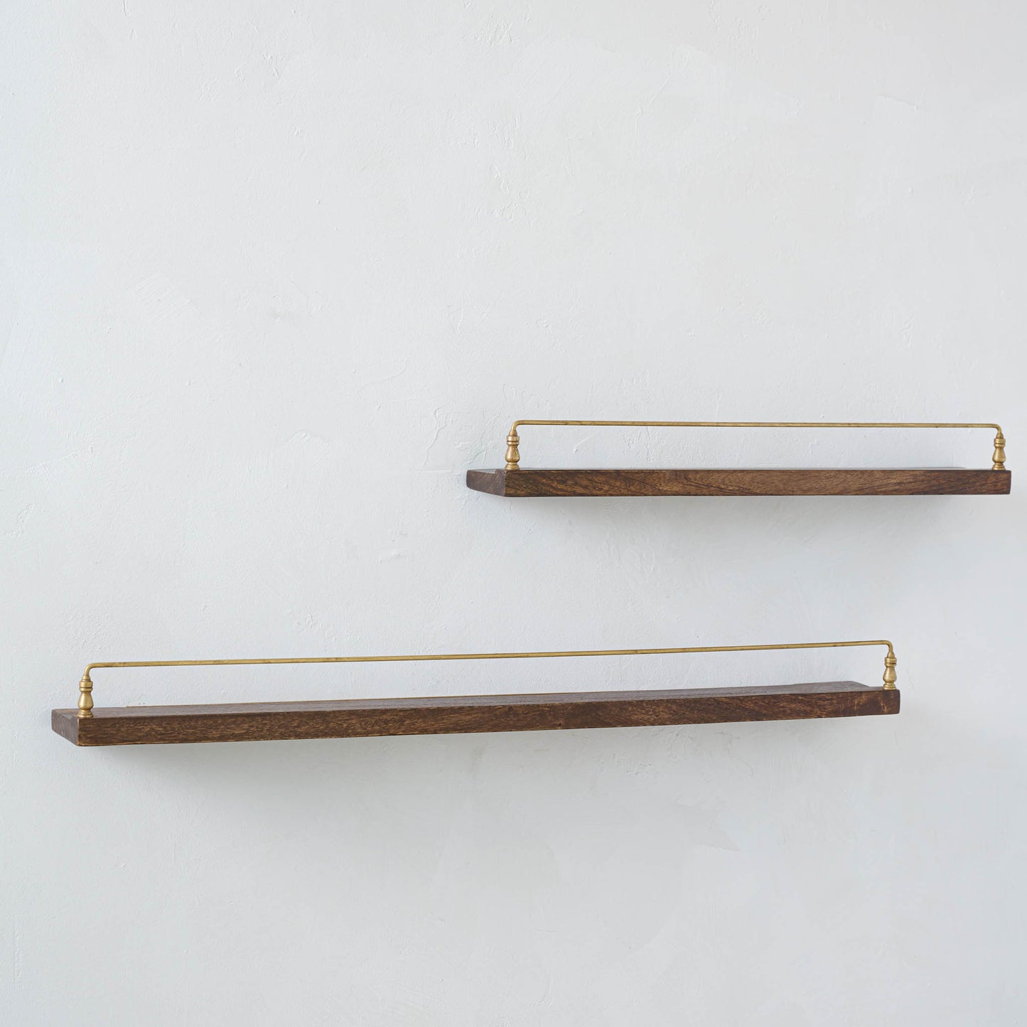 Elliott Wood and Brass Picture Ledge on both sizes hung on a wall