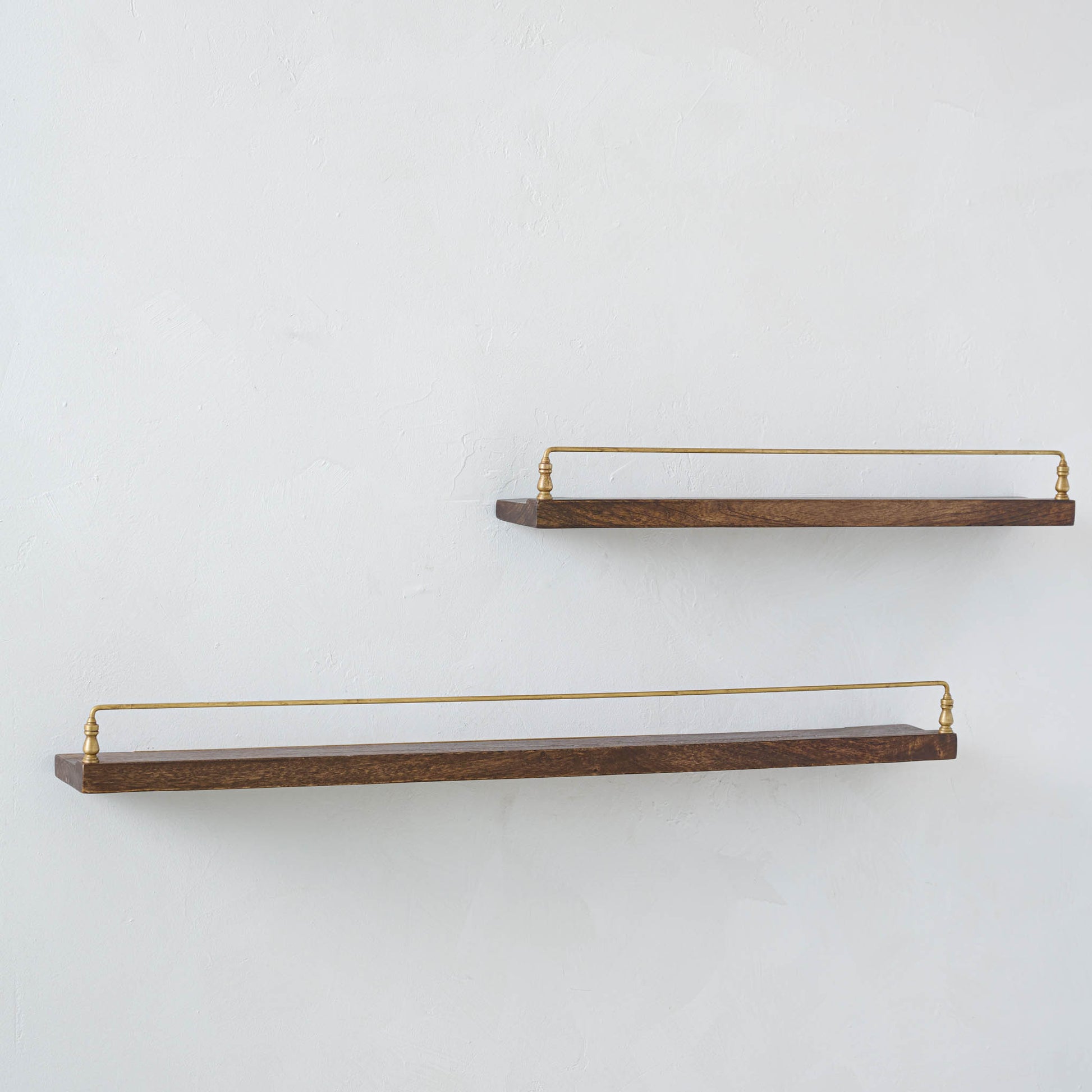 Elliott Wood and Brass Picture Ledge on both sizes hung on a wall