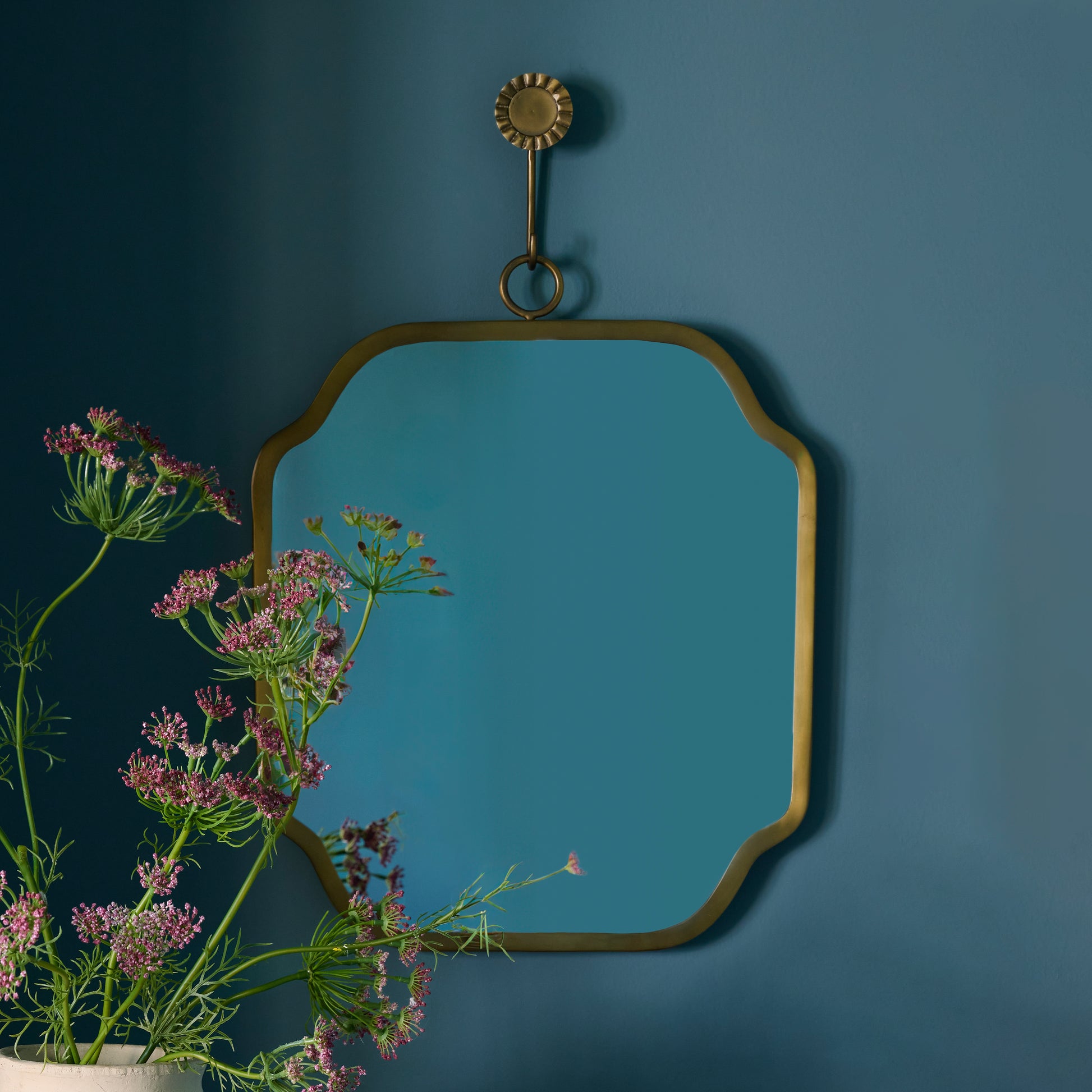 Justine Brass Hanging Mirror on a blue wall