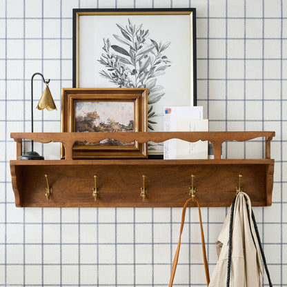 Daphne Wood and Brass Display Shelf on a wall with framed art on top