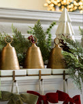 Antiqued Bell Stocking Holders on a mantle