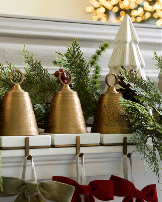 Antiqued Bell Stocking Holders on a mantle