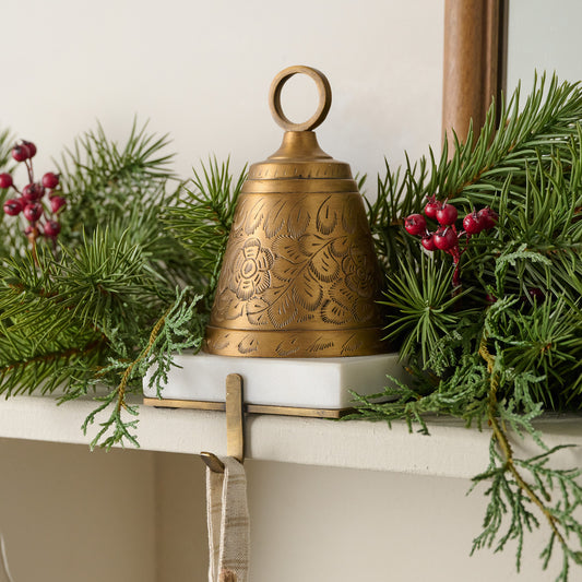 Antiqued Bell Stocking Holder shown on mantel