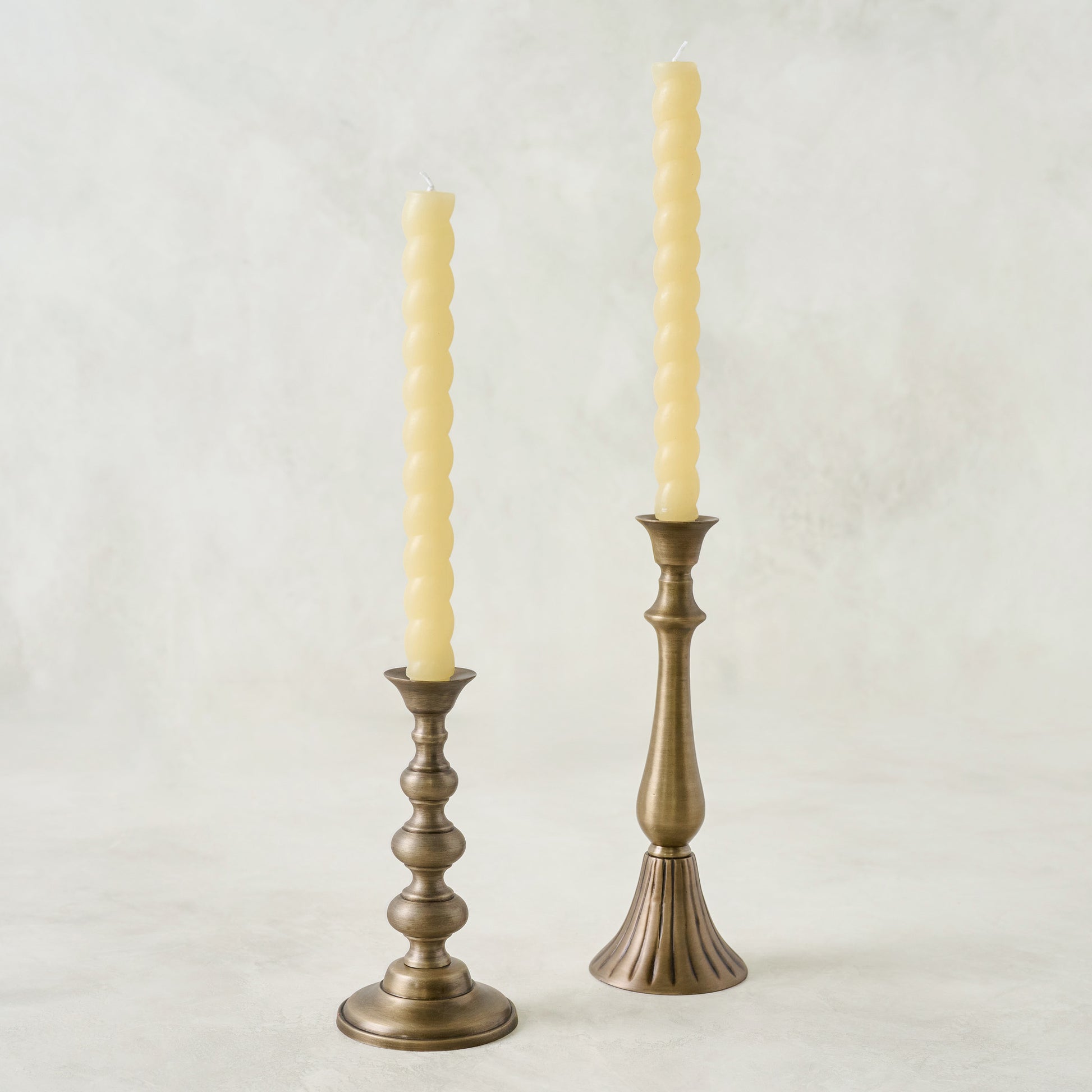 Faris Antiqued Brass Candleholders shown with twisted tapers