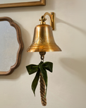 Polished Brass Etched Wall Bell shown on wall with other wall decor