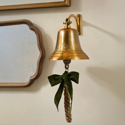 Polished Brass Etched Wall Bell shown on wall with other wall decor