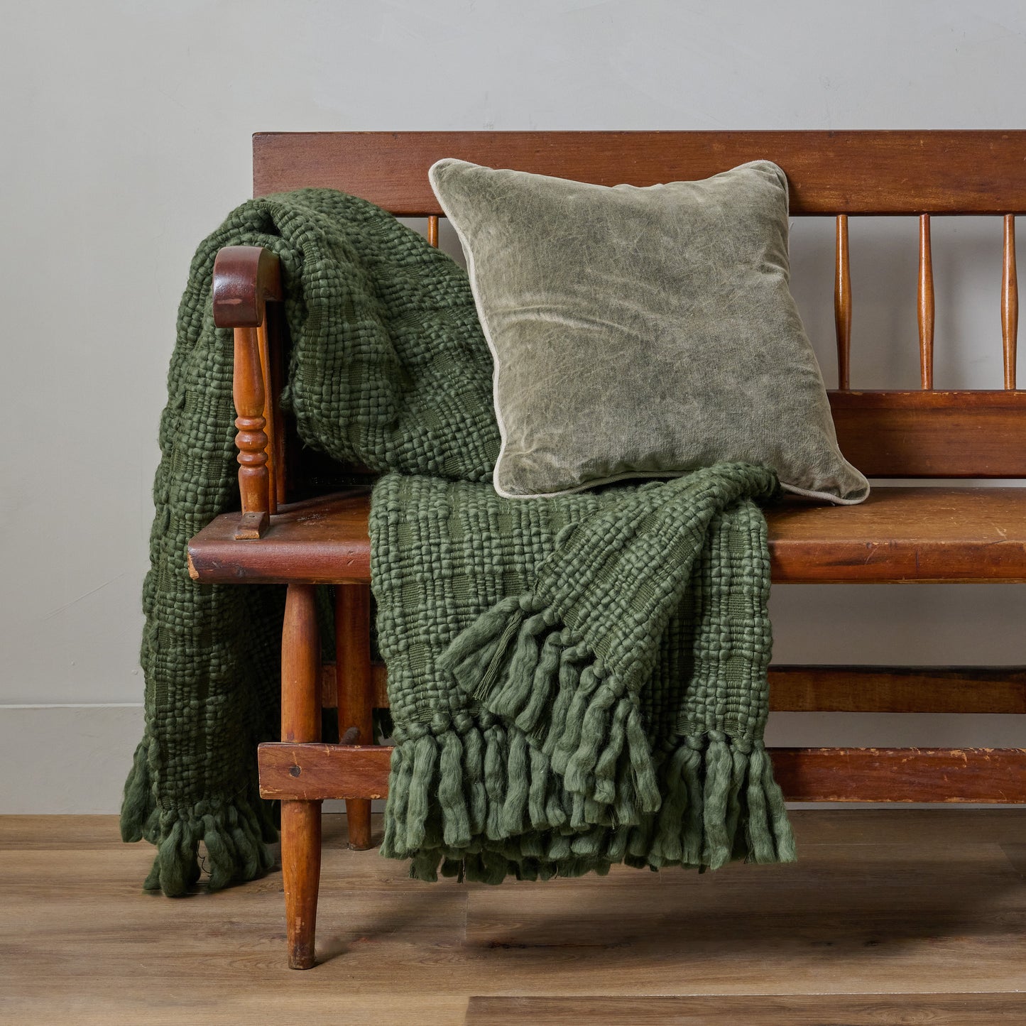 Haven Knit Throw in Forest Green shown draped over bench with throw pillow