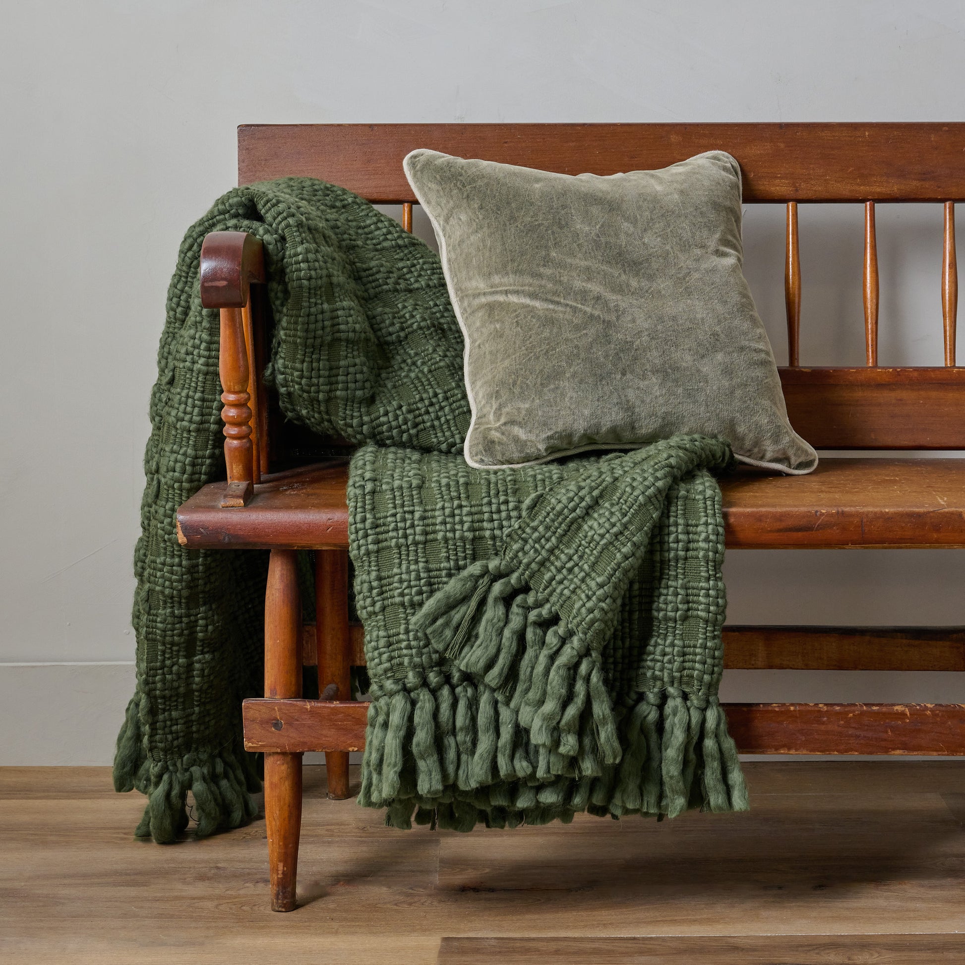 Haven Knit Throw in Forest Green shown draped over bench with throw pillow