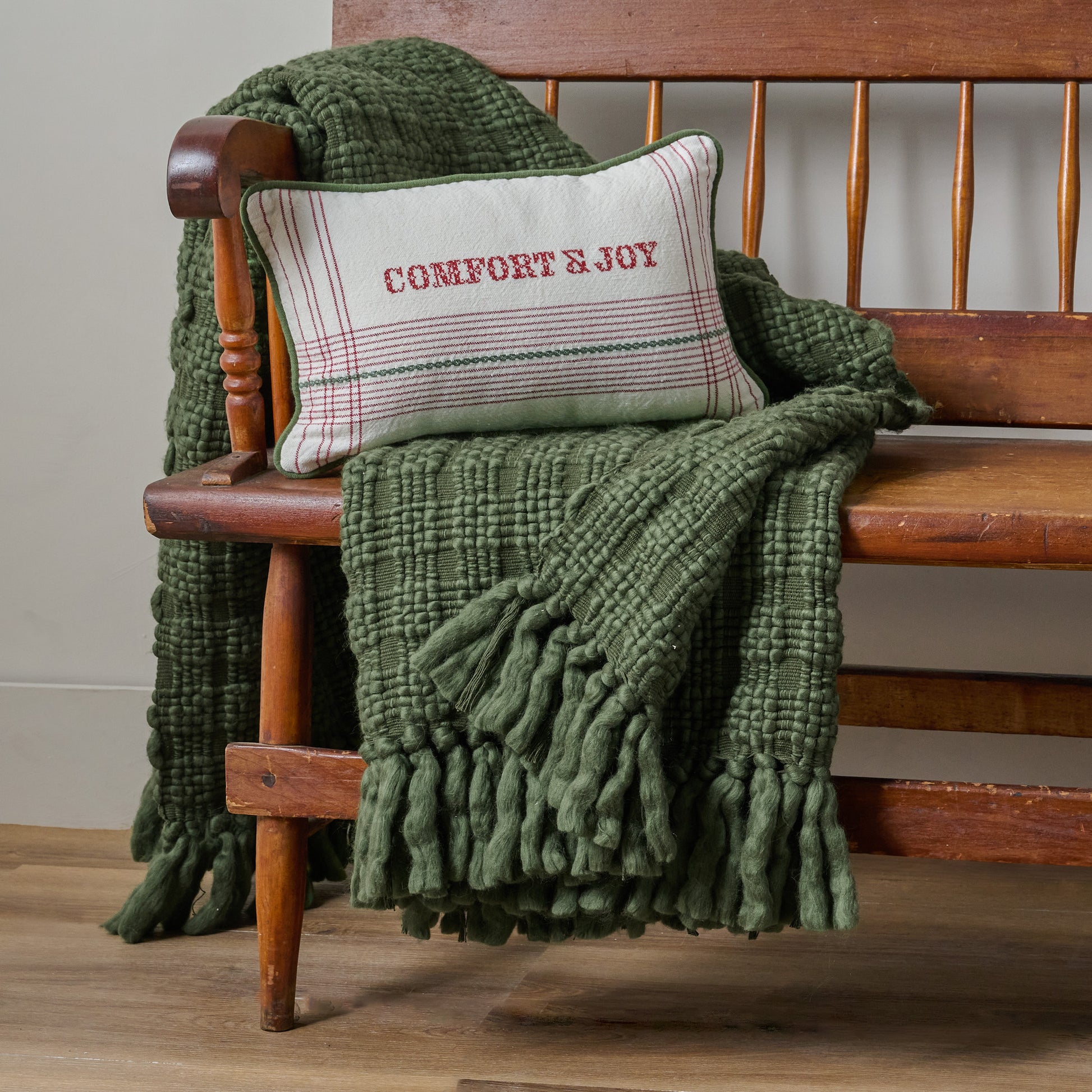Haven Knit Throw in Forest Green shown draped over bench with Comfort & Joy Pillow