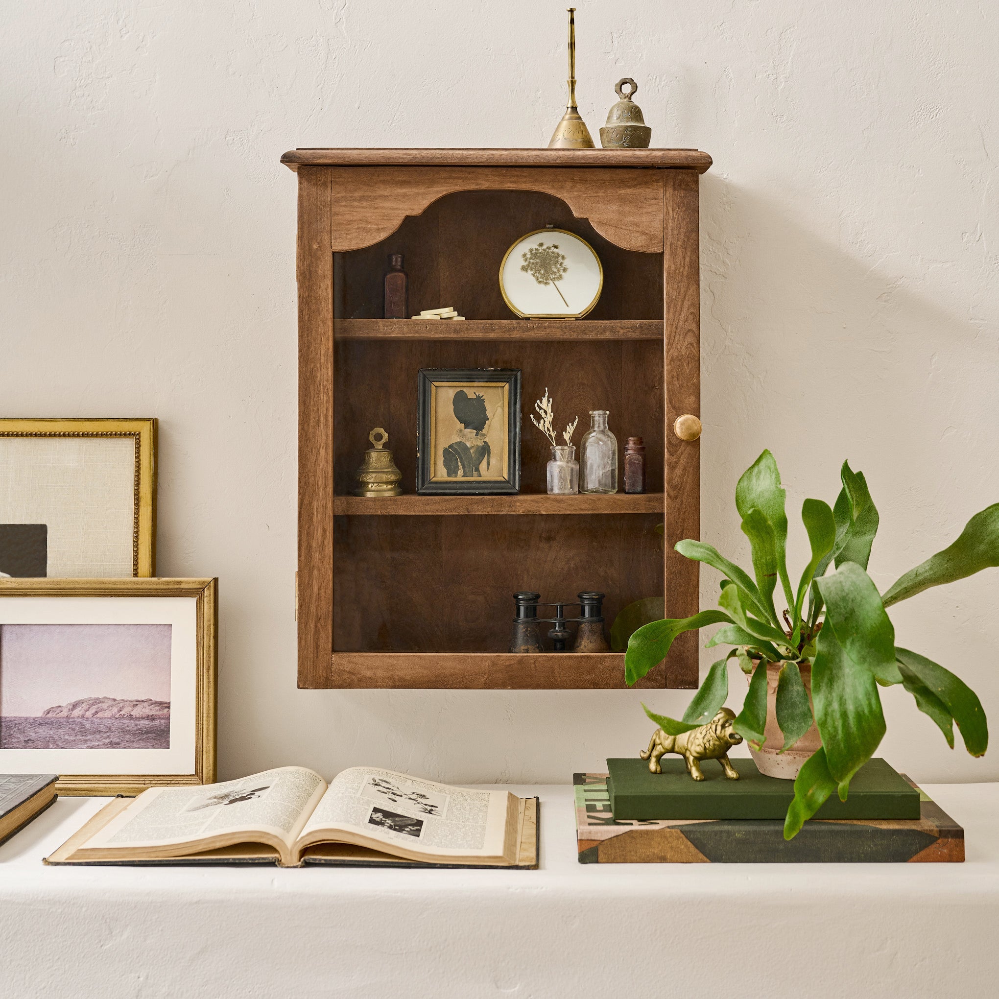 Wooden shelf with decorative items against a light wall