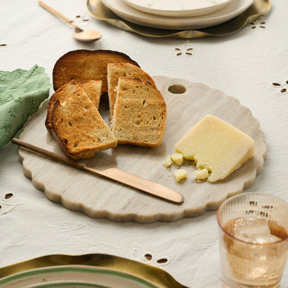 Warm Marble Scalloped Serving Board shown on table with bread and cheese