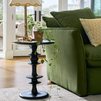 Enzo Turned Wood Side Table in color black shown styled next to sofa