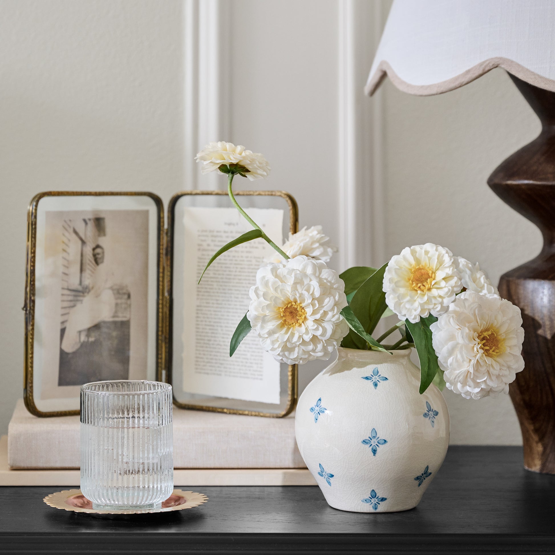 Real Touch Cream Zinnia shown in vase on nightstand