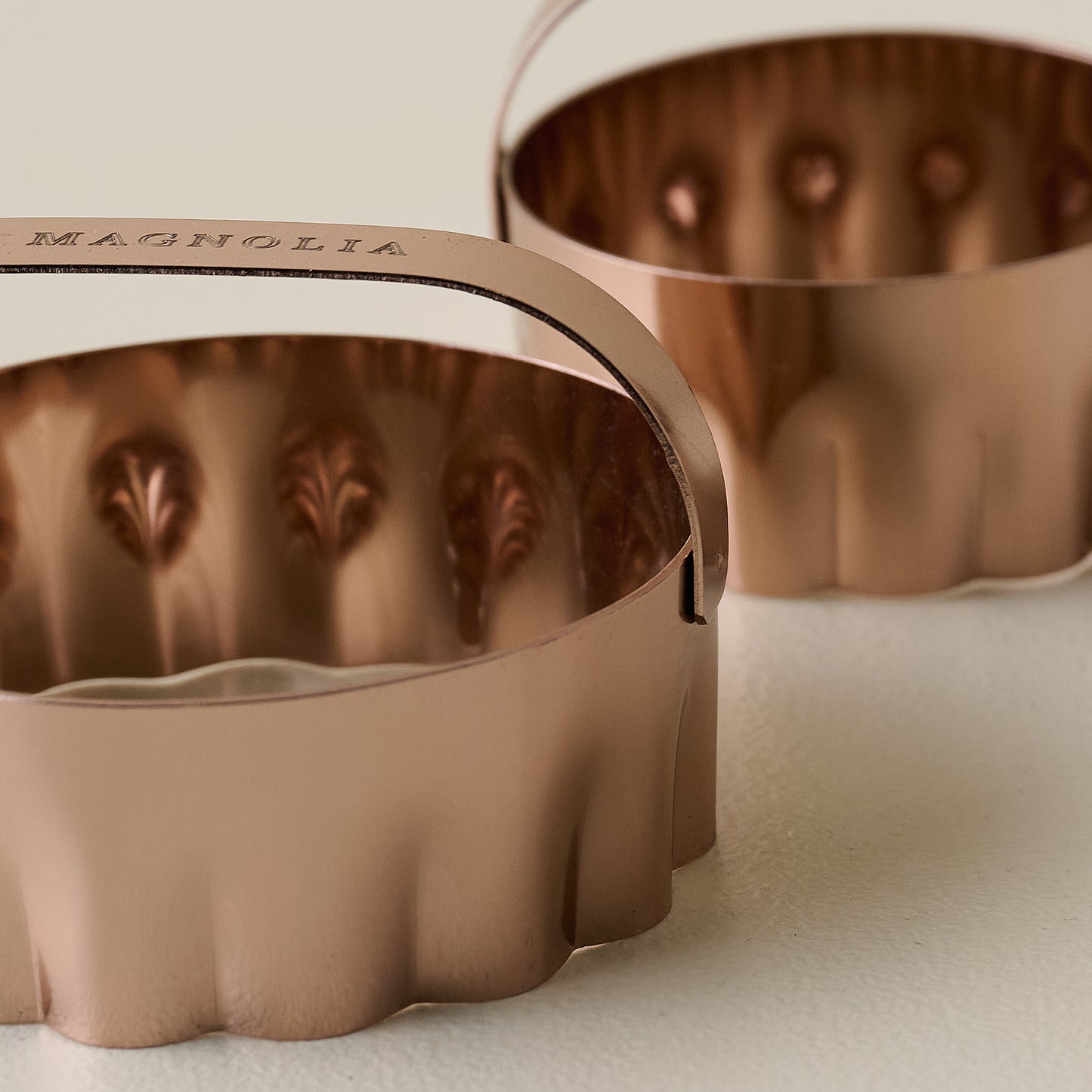 Close up view of two copper biscuit cutter with flat Magnolia branded handles