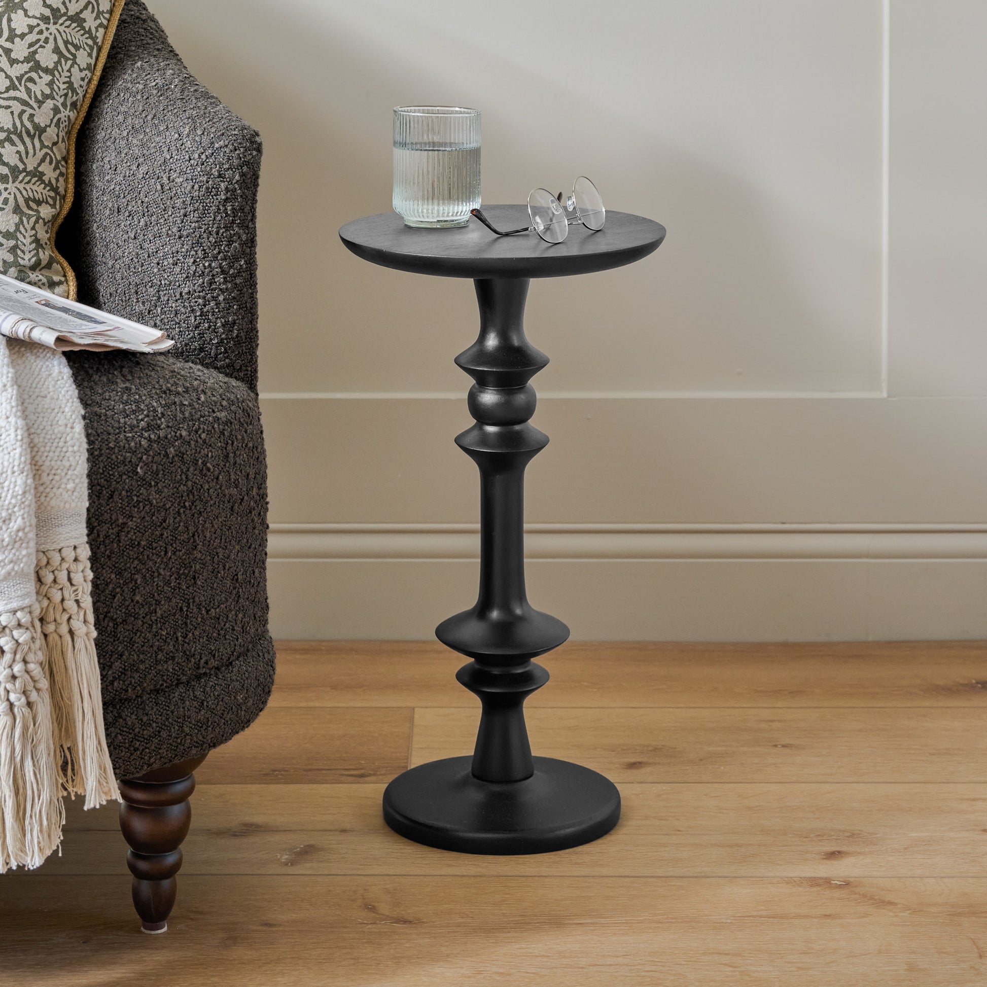 Enzo Turned Wood Cocktail Table in black shown next to accent chair