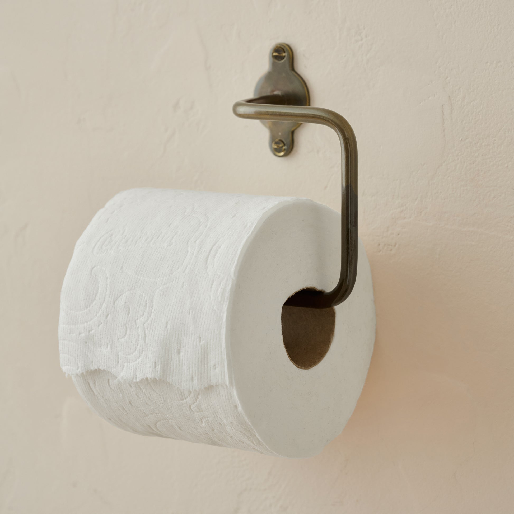 Antique Bronze Metal Toilet Paper Holder shown with toilet paper