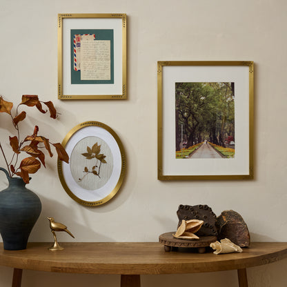 Floral Antique Brass Oval Picture Frame shown in gallery wall with other antique brass frames